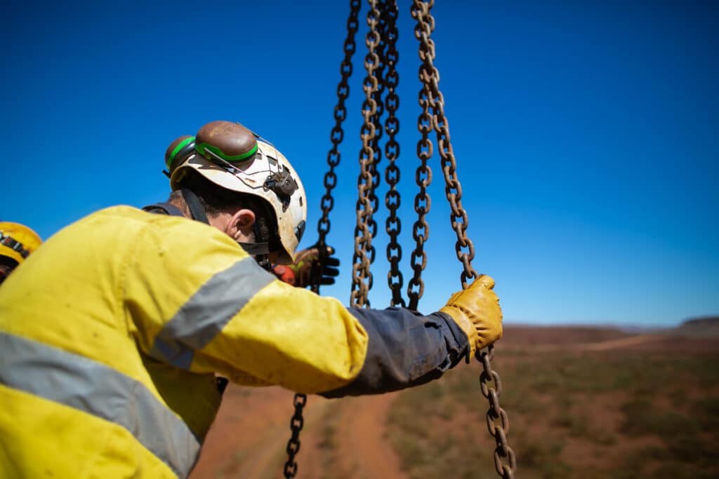 Worker in safety wear operating block and tackle